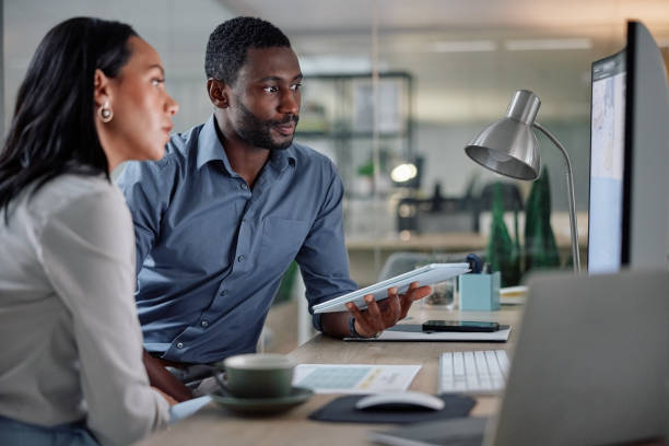 A project manager offering a Microsoft Project review to his coworker to help her determine the project management software for her personal needs.