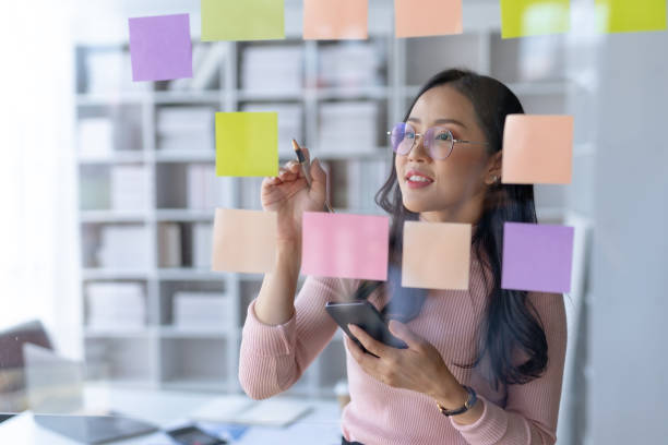 A project manager organizing sticky notes in the order that will yield the most effect project planning.